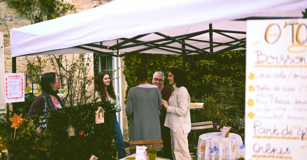 Charming outdoor gathering under a tent in a garden setting with people enjoying a relaxed moment.