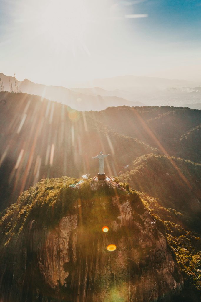 Breathtaking aerial photograph of Christ the Redeemer with sun rays over Rio de Janeiro, Brazil.